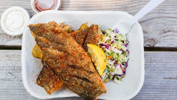 Saltbox Seafood Joint signature dishes The menu changes daily, but signature items include Fried Fish Plates (like Grouper or Flounder), Seafood Rolls, and Grilled Fish, all served with slaw and seasoned potatoes.